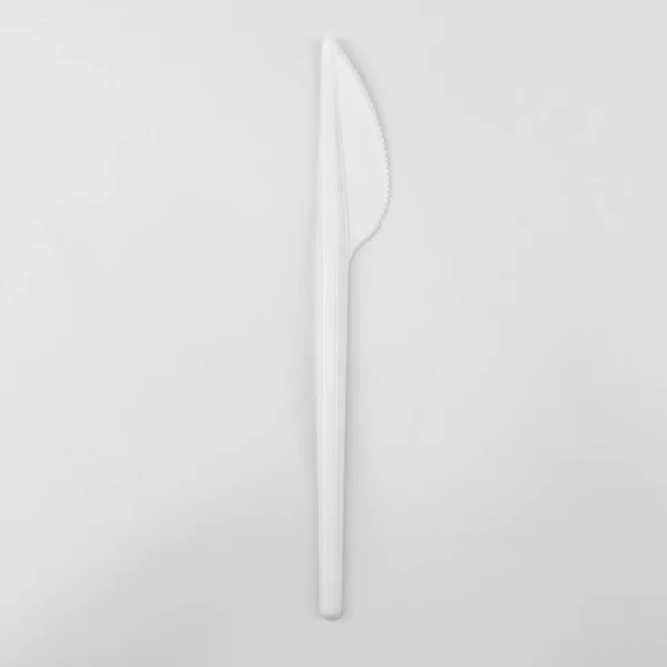 clear white small plastic knife on white background, ecological problem, closeup, square photo