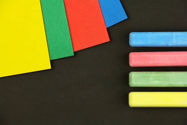 Négy színes gyermekek ceruzák és papírok fekete háttér, BL — Stock Fotó