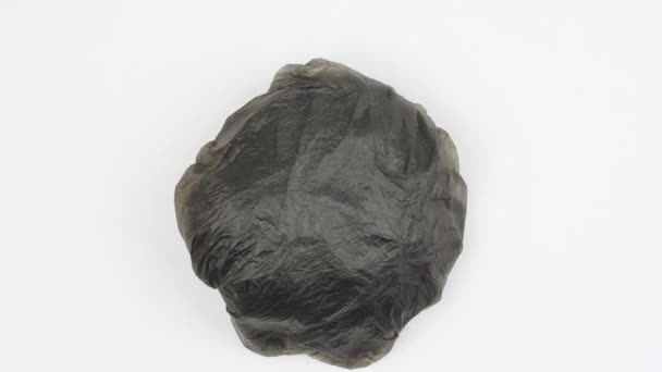 Crumpled Ball Used Black Plastic Bag Rotates White Background Increases — Stock Video