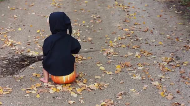 Child Black Sorcerer Witch Suit Broom Sits Pumpkin Looks Falling — Stock Video