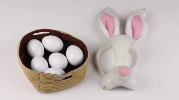 イースターの属性 ウサギの卵とマスク 人間の手は卵でバスケットを拾う — ストック動画