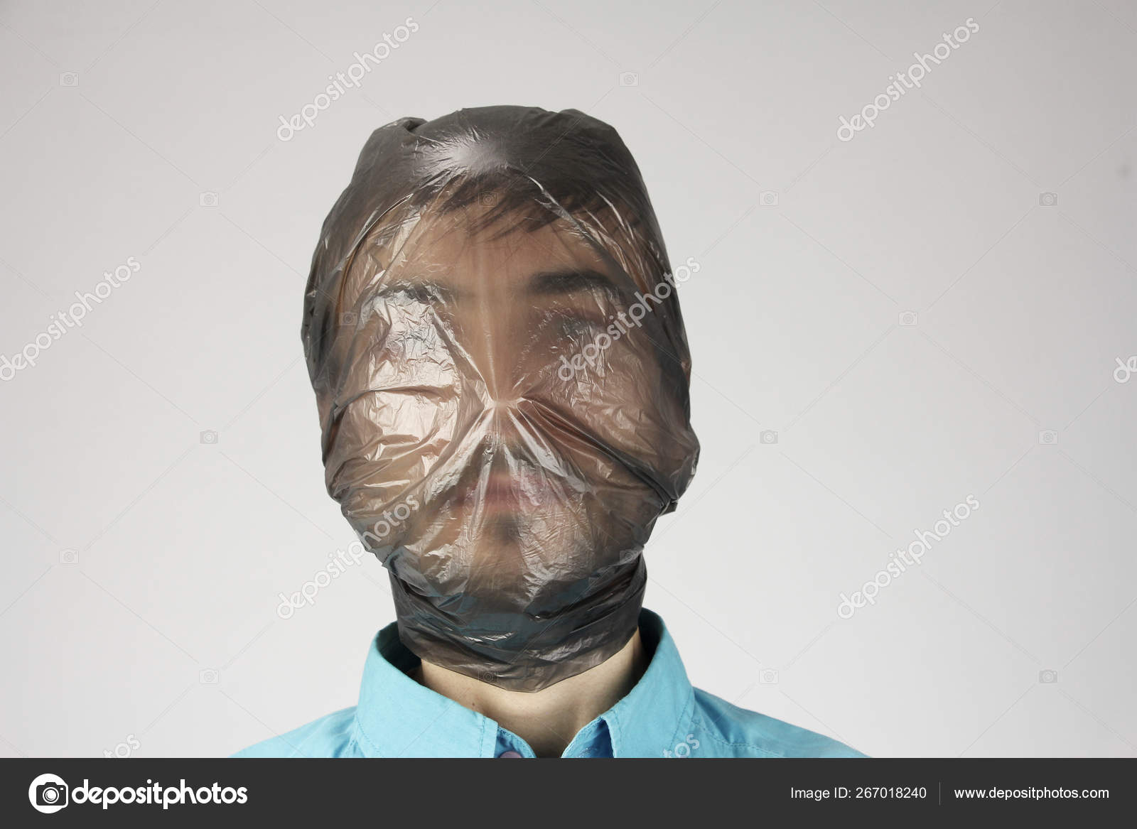 Black plastic bag wraps around a head, gray background, concept of suffocating person, big ecology problem pollution, copy space Stock Photo ©worklater 267018240
