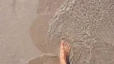 adam kum, üst görünümü ayak izleri bırakarak, deniz plajı boyunca geriye gider