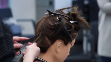 acemi kuaför bir kukla kafa, tarak ve saç ayrılık yapmak, kuaför atölyesinde eğitim, yeni meslek veya tazeleme kursu öğrenme yeni beceriler uygulamaları