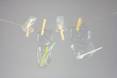 çamaşır clothespin, gri backgroun ile ip üzerinde plastik gereçleri