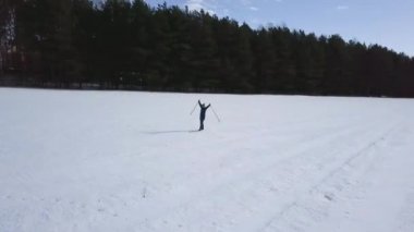karlı geniş alanda kros kayak kız sürmek, sevinç kadar eller ve eğlenmek, drone üst görünümü, drone kamera etrafında sinek   