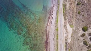 deniz kıyısıhavadan görünümü, hava durumu güneşliden bulutluya, fırtına geliyor, çalılar ile deniz ve eski asfalt yol, Kıbrıs'ta seyahat, statik kamera 