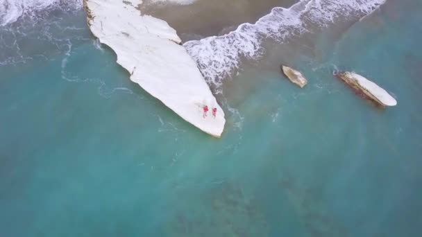 vue aérienne des loisirs familiaux sur le cap de pierre blanche à Kalymnos ou Gouverneur Plage à Chypre, père mère et fils en chemise rouge sur la côte de la mer, les gens voyageant, drone caméra voler autour    