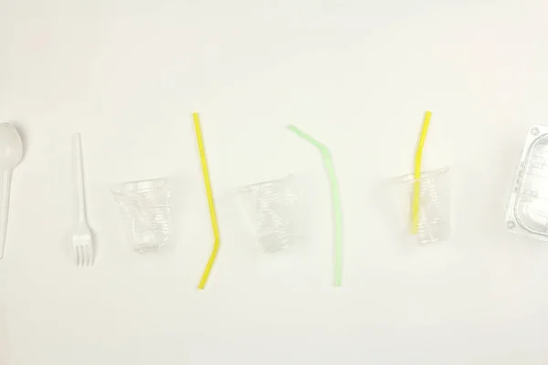 Zestaw białego użytego plastikowego naczynia jednorazowego użytku, kubek łyżki i słomy, na białym tle, śmieci lub zanieczyszczenia środowiska problem — Zdjęcie stockowe