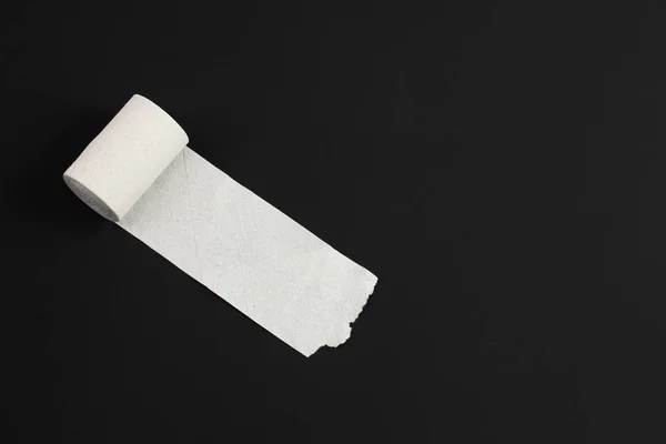 Papel higiénico blanco desenrollado sobre fondo negro, primer plano, espacio para copiar, concepto de cuaderno para pensamientos o diarrea — Foto de Stock