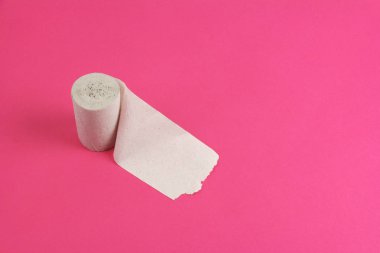 pembe arka plan üzerinde sol tarafta kaba tuvalet kağıdı standı rulo