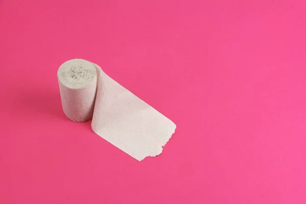 Roll of rough toilet paper stand on left side on pink background — Stock Photo, Image