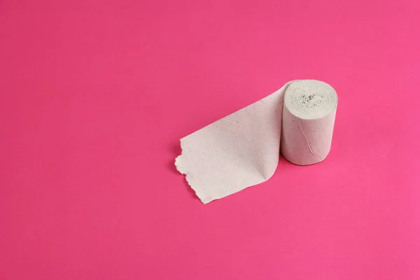 Roll of rough white toilet paper stand on pink background, close — Stock Photo, Image