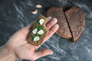 Isırılmış sandviç, soğan soğanı ve sarımsaklı ekmek, somun ekmeği, somun ekmeği, tahıllı ekşi ekmeği, kalbi, mütevazı yemek tatma numunesi, özel fırın, üst görünüm.