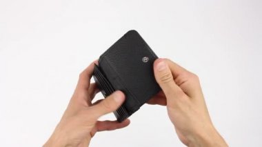 İnsan eli siyah deri cüzdan tutar, onu açar ve para arar, çanta boştur, yazıt deri, beyaz arka plan