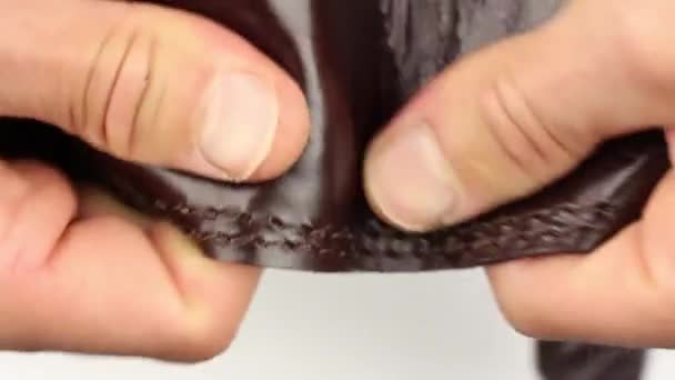人間の手のテスト茶色の自然な滑らかな光沢のある光沢のある革の作品茶色の縫い目 外側の部分と内側 バックパックの一部 製品の品質管理を確認し マクロビューを閉じる — ストック動画