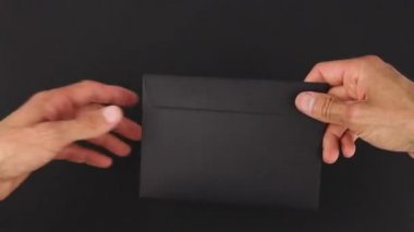 Kara arka planda siyah zarfın elden ele transferi veya yeniden yönlendirilmesi, bir el verme, başka bir mektup, şüpheli yazışmaların posta servisi, dedektiflik soruşturması için kanıt paketi