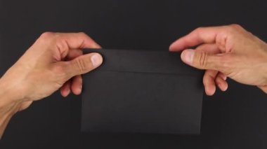 Siyah arka planda elden ele siyah zarf transferi, bir el verme, başka bir mektup, şüpheli yazışmaların gizli transferi, dedektiflik soruşturması için kanıt paketi