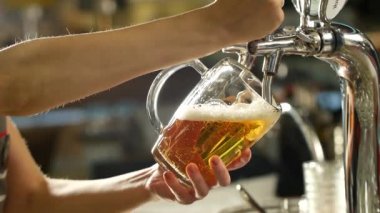 Bira en baştan dalgalar oluşturan cam içine yağıyor