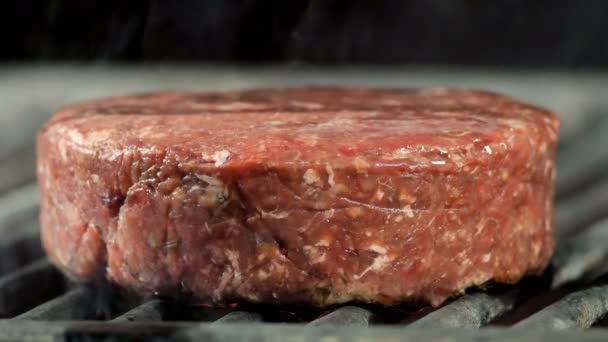 Das große Rinderschnitzel wird gegrillt, der Koch drückt das Schnitzel mit einem Eisenspachtel auf den Grill, seitliche Nahaufnahmen — Stockvideo