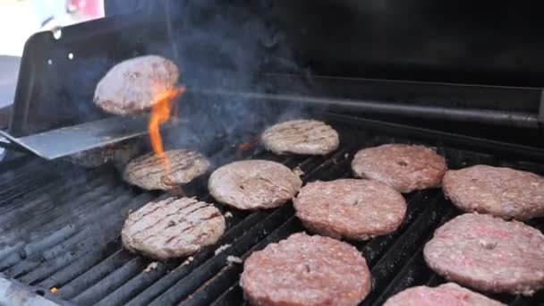 Cozinhar hambúrgueres e hambúrgueres chama grelhado hosper carne carne de porco carne de carneiro vitela e filé de frango para uma festa comida de rua. Borrifos de gordura estão voando, costeletas de churrasco são incendiadas 4k câmera lenta — Vídeo de Stock