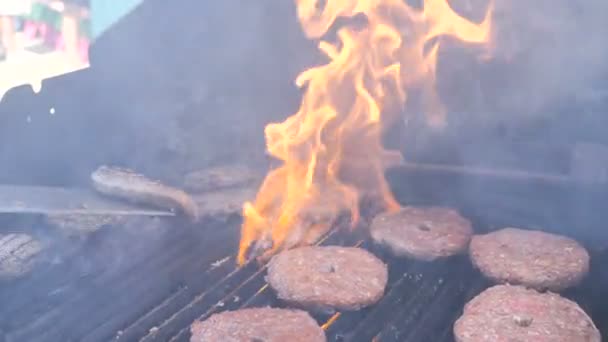 Вкусный мясной бургер на grill.Cooking гамбургеры пламя на гриле шланг мясо свинины говядина баранина телятина и куриное филе для вечеринки уличной еды. Летят брызги жира, устанавливаются котлеты для барбекю — стоковое видео