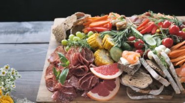 Geleneksel İspanyol tapas Kürlenmiş et çeşitli fındık peynir tabağı - chorizo, salsichon, jamon serrano, lomo ve meyve ve baharat ızgara sebze ile keçi peyniri dilimleri - ahşap servis