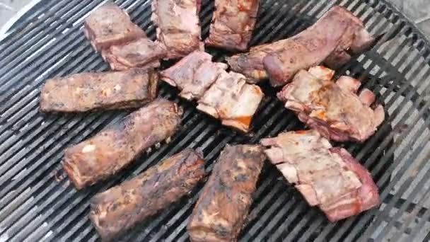 Barbacoa americana para la gran empresa en un fin de semana.4k cámara lenta Cocinar grandes piezas jugosas de carne de cerdo marinada natural grasa cruda terneros de res en un comal Grill. Top viev — Vídeos de Stock