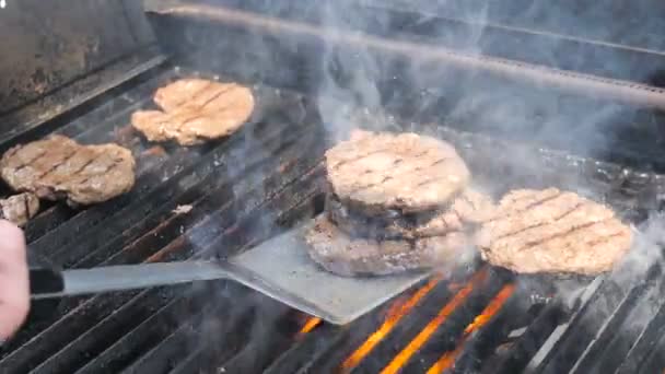 Cozinhar hambúrgueres e hambúrgueres chama grelhado hosper carne carne de porco carne de carneiro vitela e filé de frango para uma festa comida de rua. Borrifos de gordura estão voando, costeletas de churrasco são incendiados — Vídeo de Stock