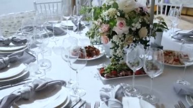 Beyaz masa örtüleri ile büyük tablolar ile Ziyafet Çeşitli Delicious Dishes Düğün için catering hizmeti ile Gülmumlar Dekor ile Çiçek düzenlemeleri. Kamera mothion Yavaş çekim 4k