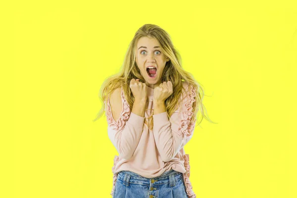 Portrait of a delighted young girl screaming isolated over yellow background. — Stock Photo, Image