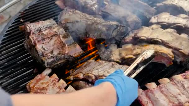 American Grill, Cook vira a carne na grelha com Fire Flames. Fritar carne fresca costeletas de porco de churrasco de frango, hambúrguer Kebab, churrasco, churrasco, Josper, carne bovina. Close Up ensolarado ao ar livre 4k — Vídeo de Stock