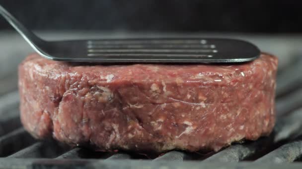 Koki dengan spatula besi menekan potongan daging ke panggangan dengan potongan daging akan asap cahaya dari bara — Stok Video