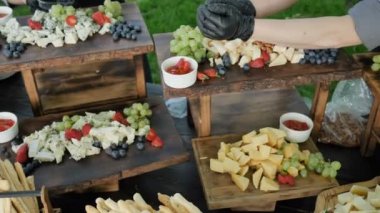 Büyük çeşitli doğal ve sağlıklı organik peynir Cheder Gouda Parmesan ve meyve çilek ve genç şarap 4k ziyafeti için fındık. Yavaş çekim kamera döndürme 4k. Catering hizmeti.