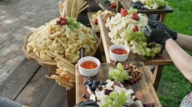 Büyük çeşitli doğal ve sağlıklı organik peynir Cheder Gouda Parmesan ve meyve çilek ekmek çubukları ve genç şarap 4k ziyafeti için fındık. Yavaş çekim kamera döndürme. Catering hizmeti.