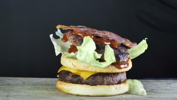 Půl bochník na Burger s hlávkovým salátem na vrcholku a dva plátky sýra smažený plynovým hořákem a další polovinu bochník, na kterém je nová vrstva salátu a kotlety s — Stock video