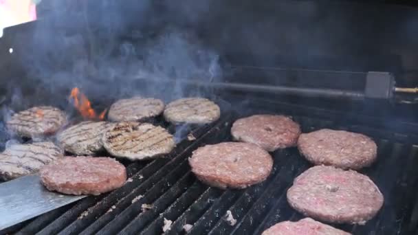 Vaření hamburgery plamenný pohostinný maso vepřový Hovězí skopové a Kuřecí filé pro pouliční jídlo. Odlétající švy jsou v plamenoji, kotlety na grilování jsou nastaveny na oheň 4k pomalý pohyb — Stock video