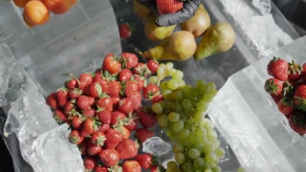 Conceito de produtos orgânicos e naturais. Uvas frescas de morango puro e outras frutas sem conservantes e produtos químicos no gelo 4k câmera lenta — Vídeo de Stock
