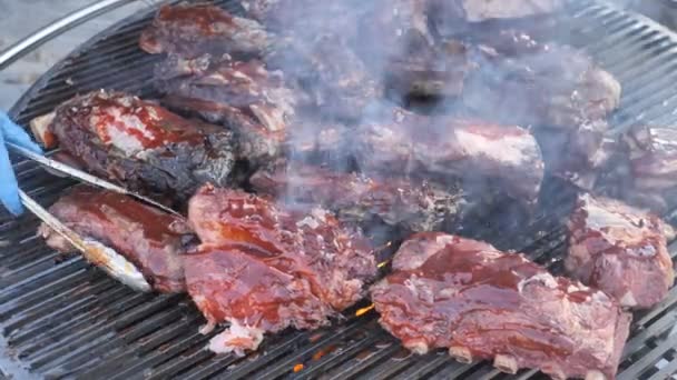 Barbacoa americana, Freír carne fresca, Barbacoa de pollo, Cerdo, Costillas, Kebab, Hamburguesa, Barbacoa, Josper, Carne de res. Primer plano soleado al aire libreChef convierte la carne en la parrilla con llamas de fuego 4k — Vídeos de Stock