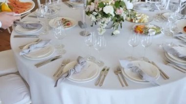Beyaz masa örtüleri ile büyük tablolar ile Ziyafet çeşitli Delicious Yemekleri, Düğün için catering hizmeti ile Güller mumlar Dekor ile Çiçek düzenlemeleri. Kamera mothion Yavaş çekim 4k.