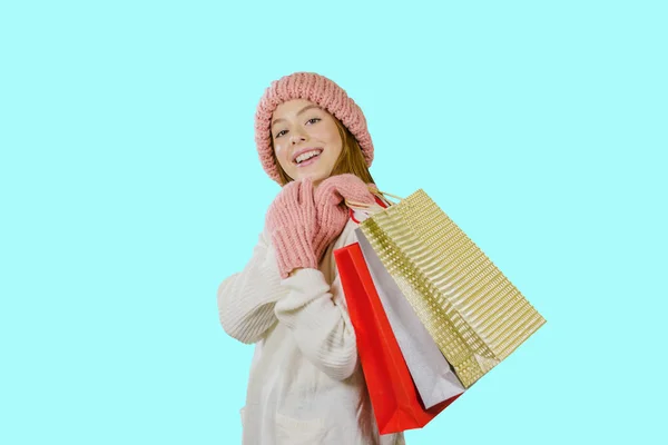 Lány, hosszú vörös hajú, fehér pulóvert egy mosoly birtokában csomagok ajándékokat egy elszigetelt háttér — Stock Fotó