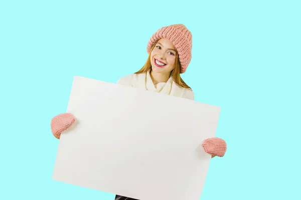 Beautiful girl holding a blank poster for text or advertising — Stock Photo, Image