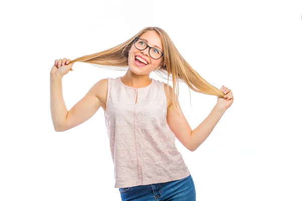 Carino giovane donna bionda in occhiali con un sorriso sul viso tiene i capelli con entrambe le mani a parte, le emozioni di una donna che filma su uno sfondo isolato — Foto Stock