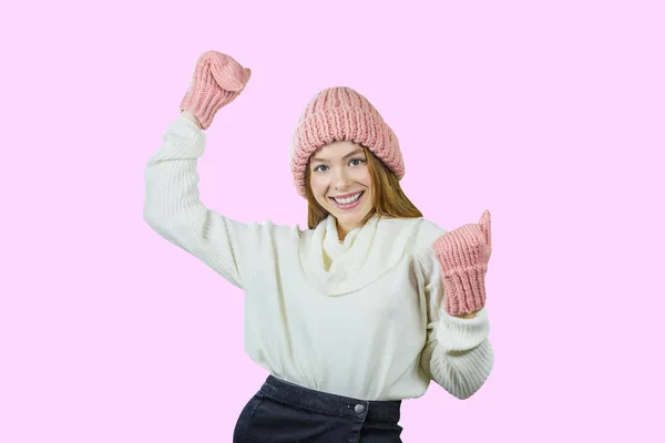 Ritratto ravvicinato di un sorriso dentato di una giovane ragazza dai capelli rossi che indossa un cappello rosa e guanti. Felice donna sorridente su uno sfondo di rose isolate in studio. Copia concetto di vita spaziale, inverno — Foto Stock