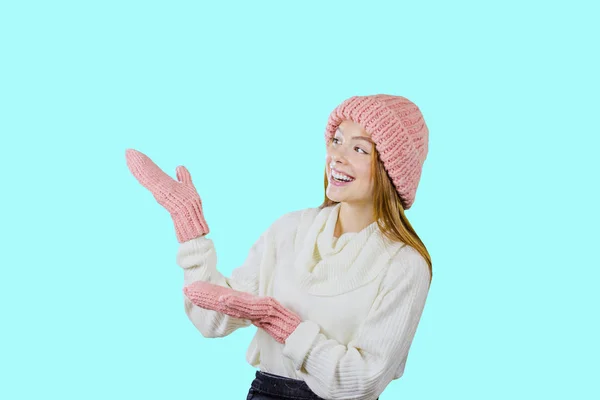 Menina de cabelos vermelhos atraente, olha de surpresa e aponta as mãos para o espaço livre em um fundo isolado — Fotografia de Stock