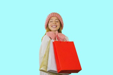 Gülümseme ile beyaz bir kazak uzun kırmızı saçlı kız izole bir arka plan üzerinde hediyeler ile paketleri tutar