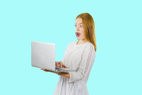 Młoda kobieta trzyma usta szeroko otwarte, patrząc zaskoczony, rozprzestrzeniania rąk pracujących na laptopie komputer PC izolowane na niebiesko. Ludzie szczerej emocji koncepcji stylu życia. — Zdjęcie stockowe