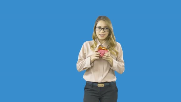 Misterioso bonita loira esperando por um presente, segurando uma caixa com um presente e sorrindo em um fundo isolado — Vídeo de Stock