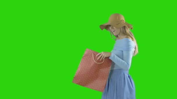 Vrouwen gaan winkelen. In het voorjaar houdt ze boodschappentassen in haar handen op een geïsoleerde achtergrond. — Stockvideo