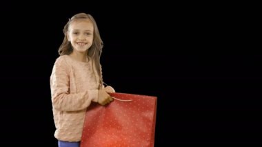 Çocuklar yeni bir satın alma hediye zevk, küçük bir kız elinde bir paket tutar açar ve gülümseyerek sevinir ve ağzını geniş açarak, duygular, çocuk çekim, bir çekim